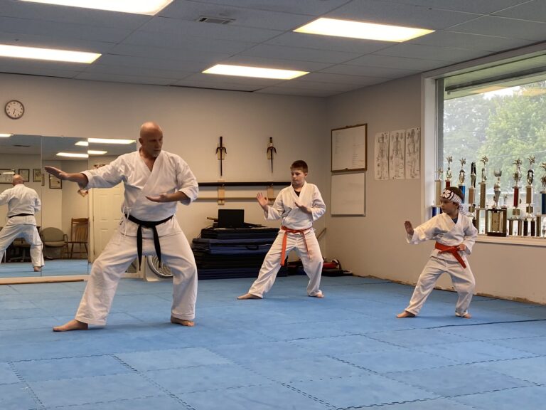 Image of Charlestown, Indiana Shotokan Karate Sensei training kata with his two orange belt students.